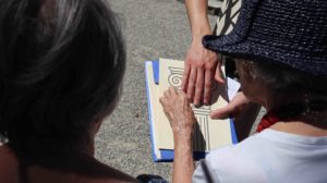 visite tactile au jardin botanique, 2 mains au contact d'un document